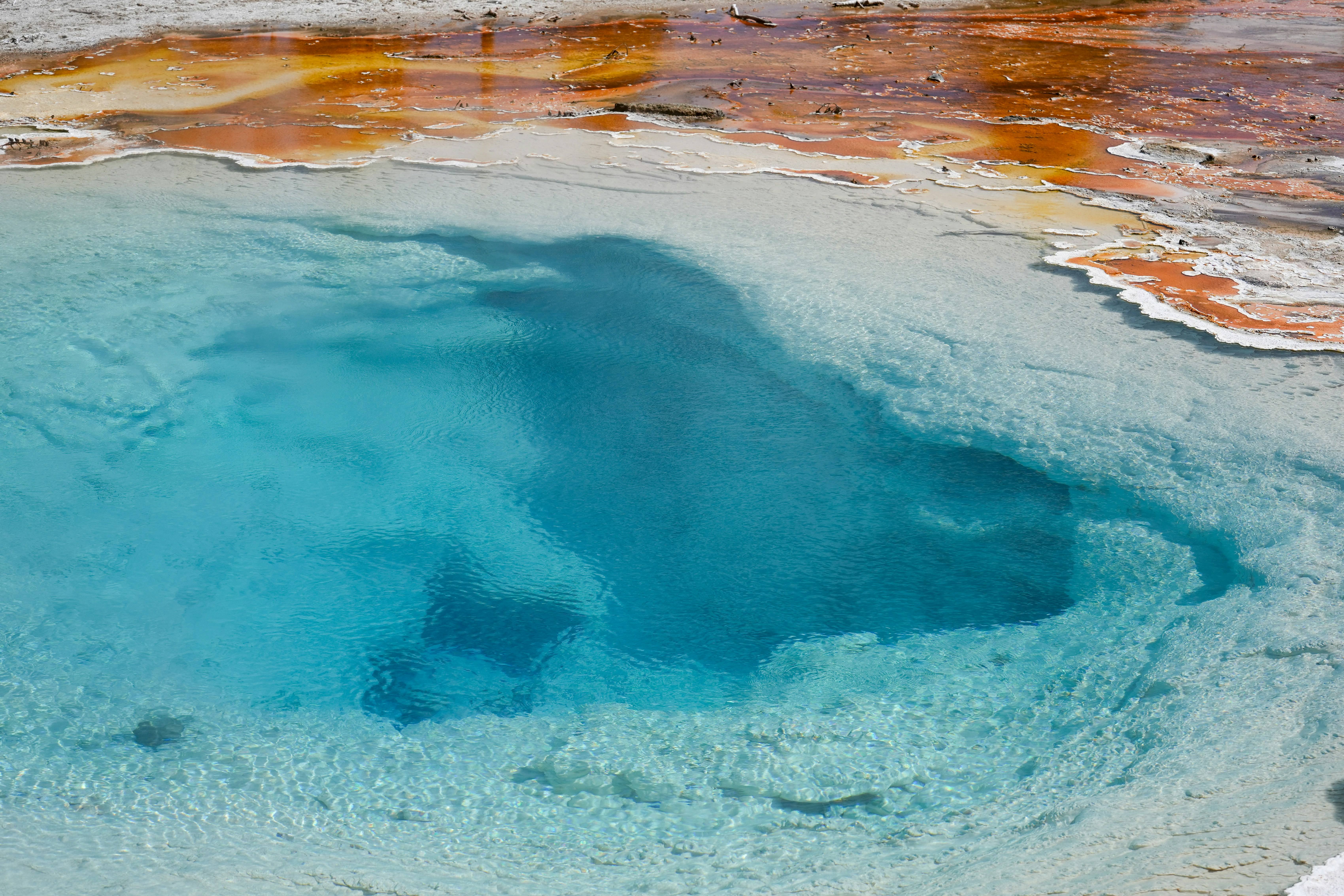 Natural geothermal spring with vibrant blue water and mineral deposits
